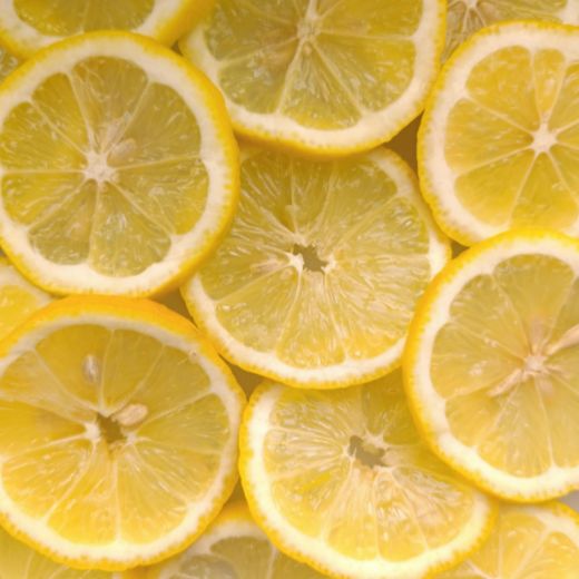 A bright, overhead view of overlapping fresh yellow lemon slices, showing juicy citrus pulp and seeds.